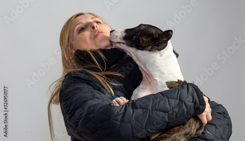 Fotografie Woman with her bull terrier bitch in affectionate situation