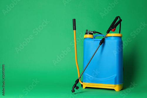 Manual insecticide sprayer on green background, space for text. Pest control