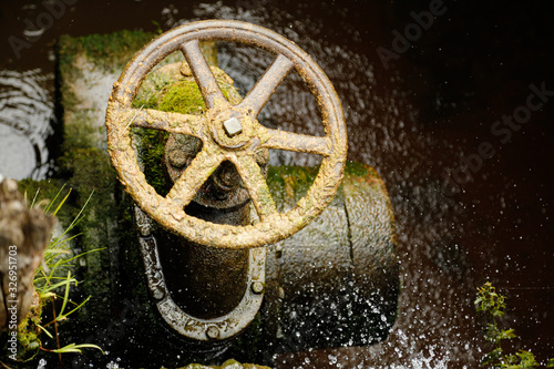 Old steel water wheel in the middle of a forest