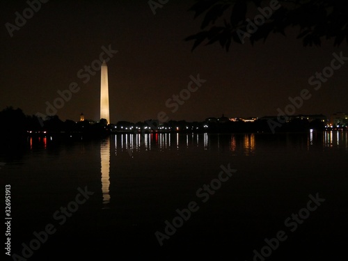 Wide shot of the Washington Monument with night lights reflected in the waters of Potomac River.