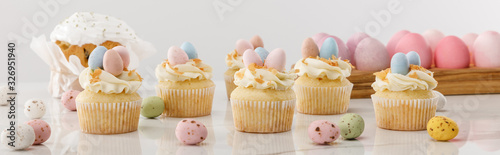 Photography Delicious cupcakes with colorful painted chicken and quail eggs near easter cake