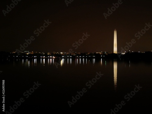 The Washington Monument with night lights of Washington, D.C. reflected in the waters of Potomac River.