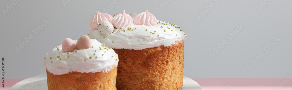 Delicious easter cakes on round board on grey background, panoramic shot Delicious easter cakes on round board on grey background, panoramic shot