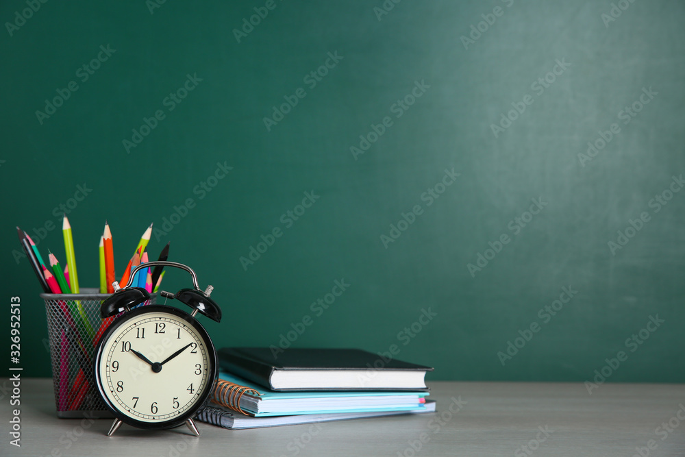 Alarm clock and school stationery on white wooden table, space for text. Doing homework - obrazy, fototapety, plakaty 