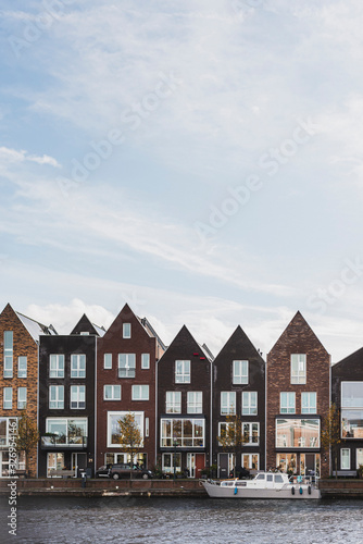 Front view of colorful typical dutch houses on the water channel of Haarlem.