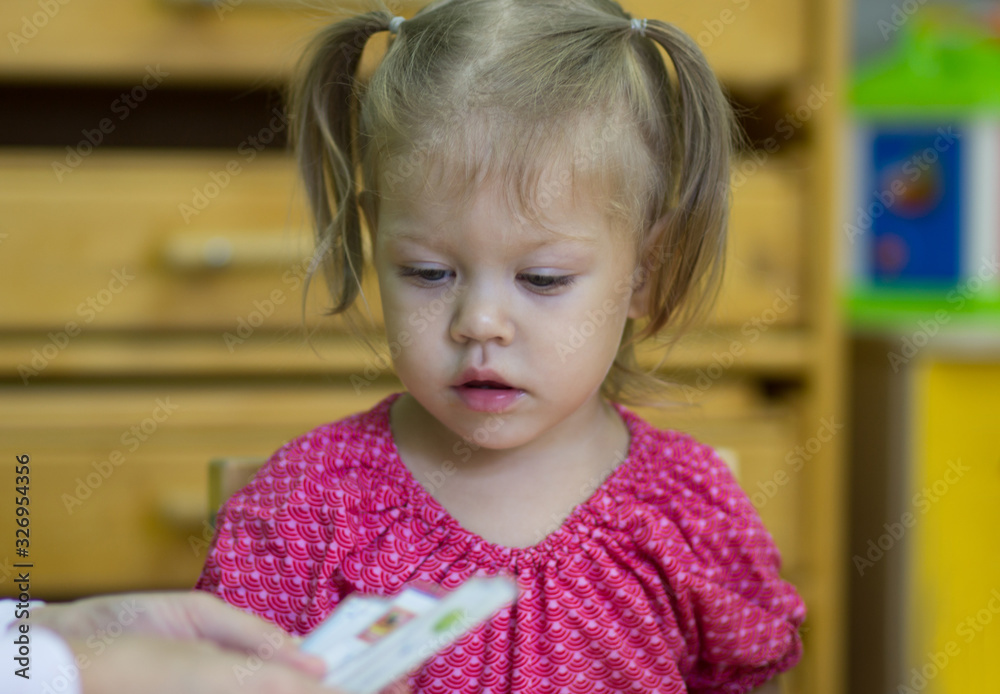 Portrait of caucasian child two years old looking at cards on class exercise