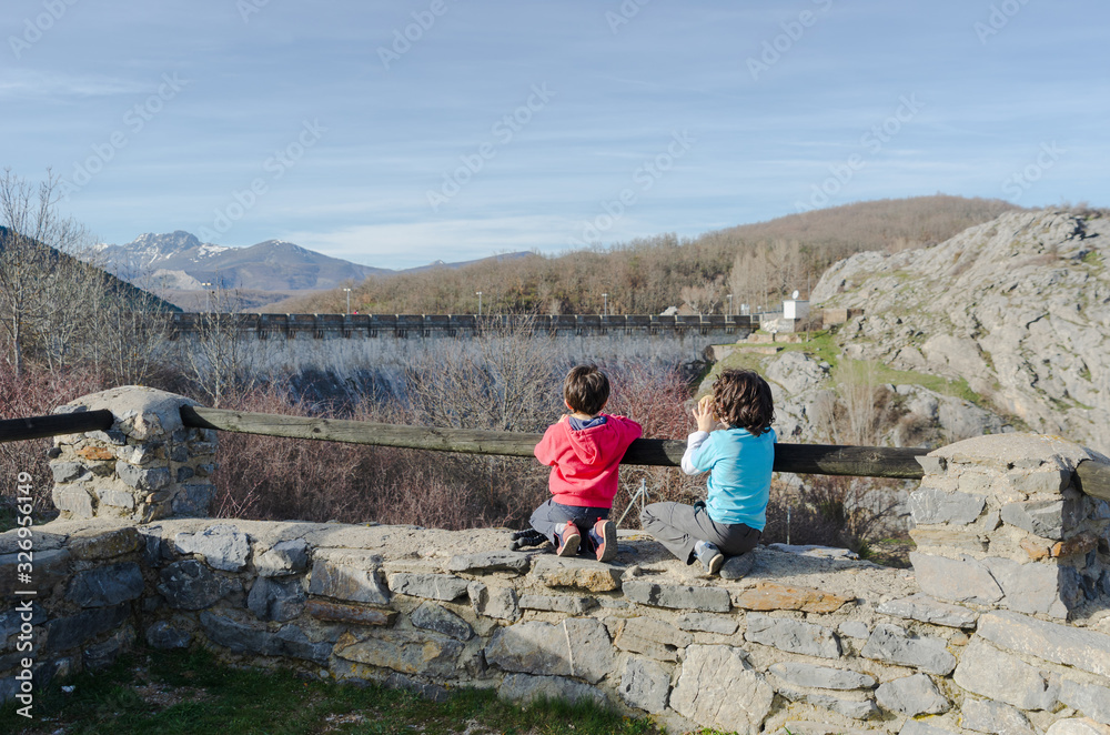 little kids enjoying the landscapes views in the mountains of Palencia, Spain, during the winter ending and the spring beginning in a warm sunny day