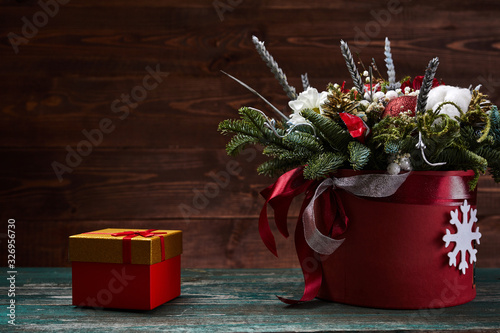 flowers in red paper box on wooden background. Winter bouquet with fir branches. Valentines day concept.
