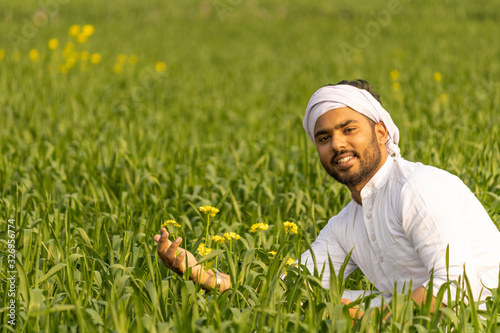 Farmer sitting in wheat field at vegetative stage