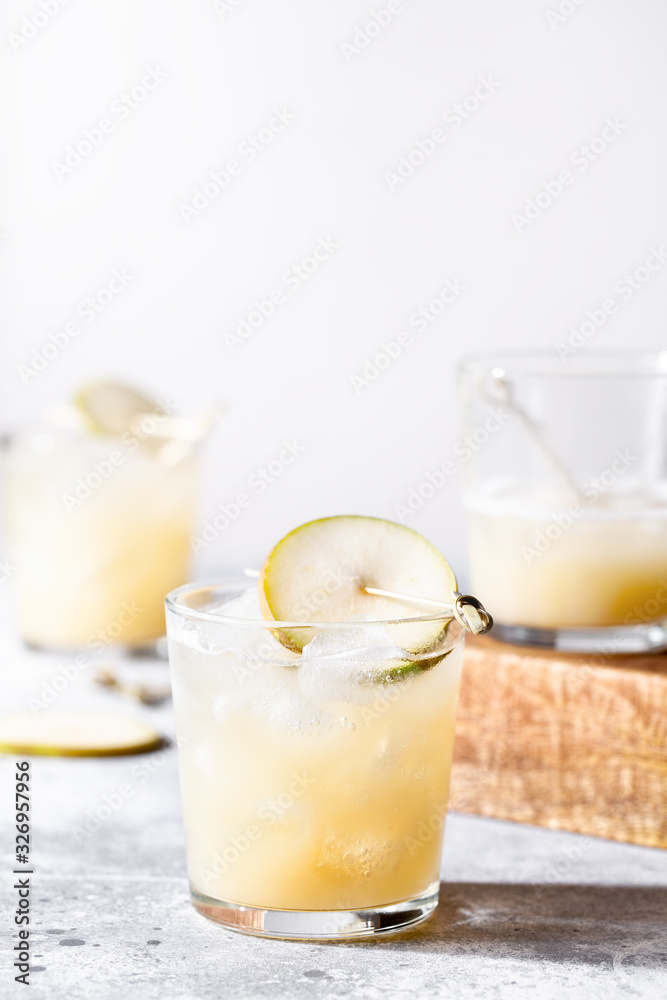 A short glass of refreshing pear soda water mocktail or cocktail on gray concrete background. Non alcoholic summer drink. Selective focus, vertical orientation, copy space A short glass of refreshing pear soda water mocktail or cocktail on gray concrete background. Non alcoholic summer drink. Selective focus, vertical orientation, copy space