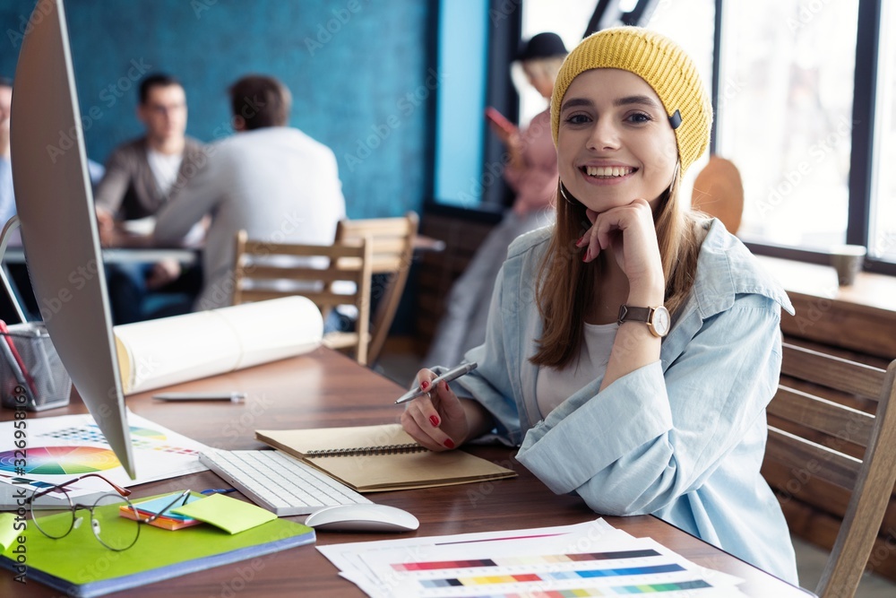 Portrait of a happy casual businesswoman sitting at her workplace in office Portrait of a happy casual businesswoman sitting at her workplace in office