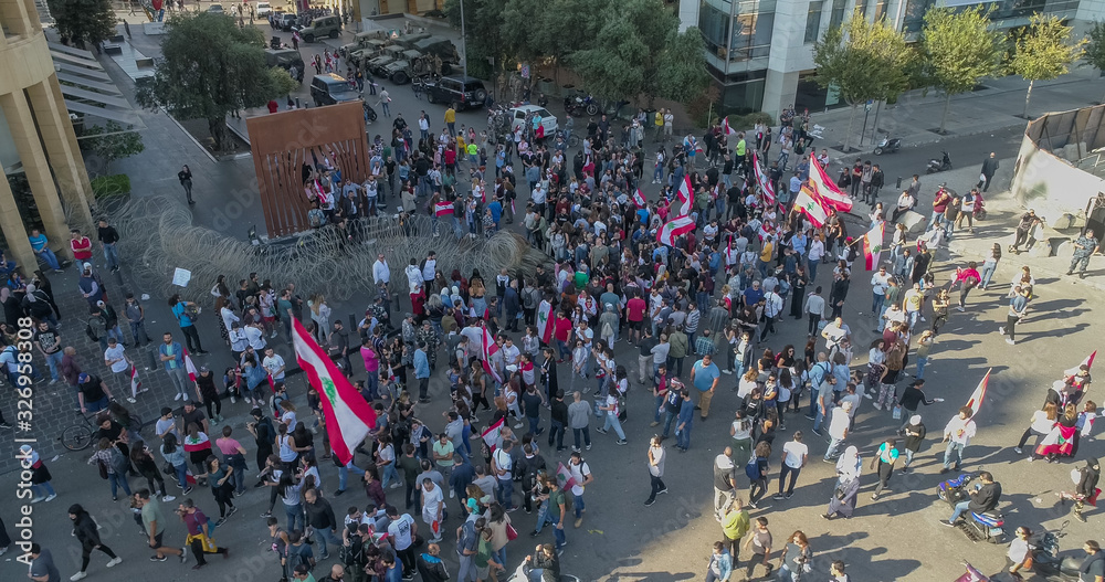 Obraz premium Beirut, Lebanon 2019: Aerial drone shot of numerous protestes at Martyrs' Square facing the police and trying to remove wires blocking the road.