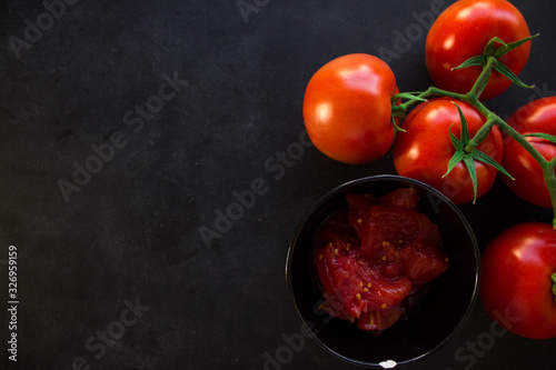 Red tomato and a bowl of chopped tomatoes