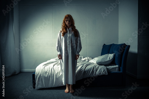Foto creepy demoniacal girl in nightgown standing in bedroom