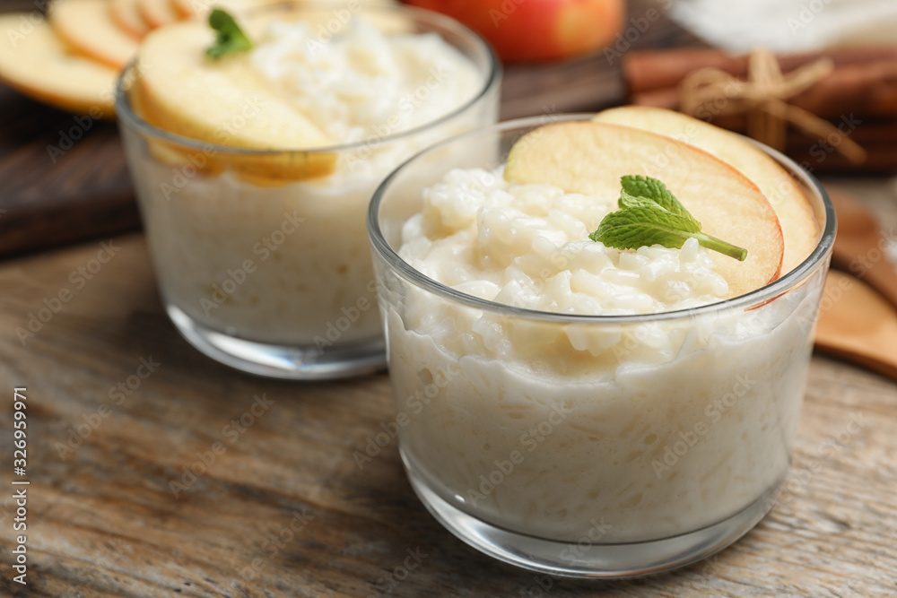 Delicious rice pudding with apple on wooden table, closeup Delicious rice pudding with apple on wooden table, closeup