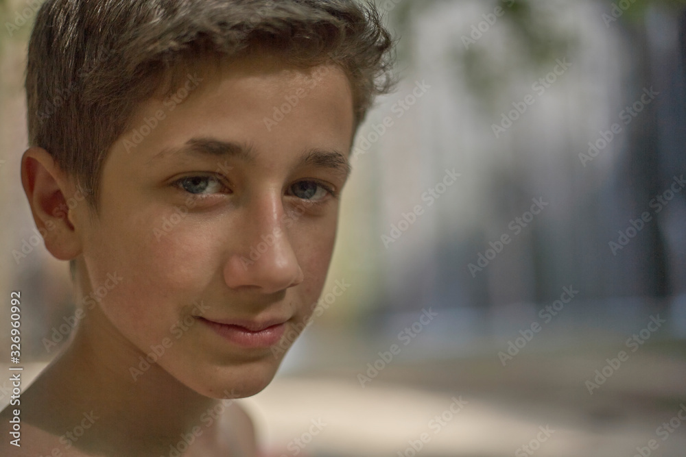 Closeup of a handsome self-confident young teenager in summer relaxed happy mood on his face Closeup of a handsome self-confident young teenager in summer relaxed happy mood on his face