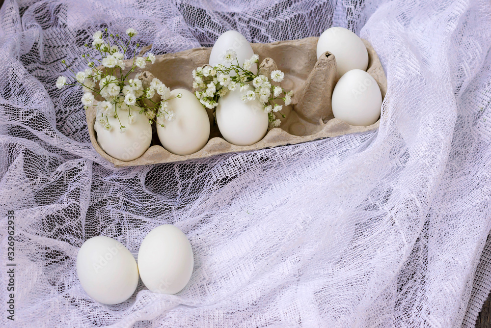 Happy Easter. White eggs in a stand on a wooden background with white gypsophila flowers. Holidays concept. Trend.