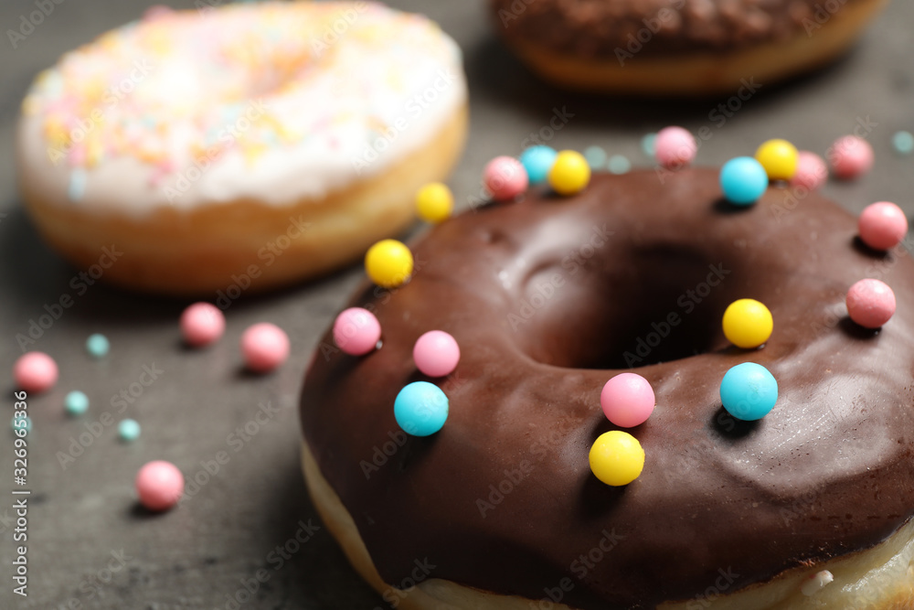 Yummy donut with colorful sprinkles on dark table, closeup Yummy donut with colorful sprinkles on dark table, closeup