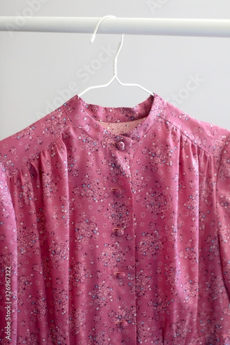 Purple floral vintage dress on a clothing rack. Selective focus. © jelena990