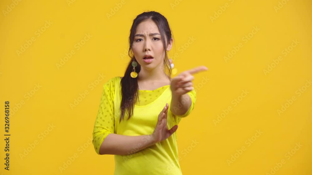 asian girl showing no gesture isolated on yellow asian girl showing no gesture isolated on yellow