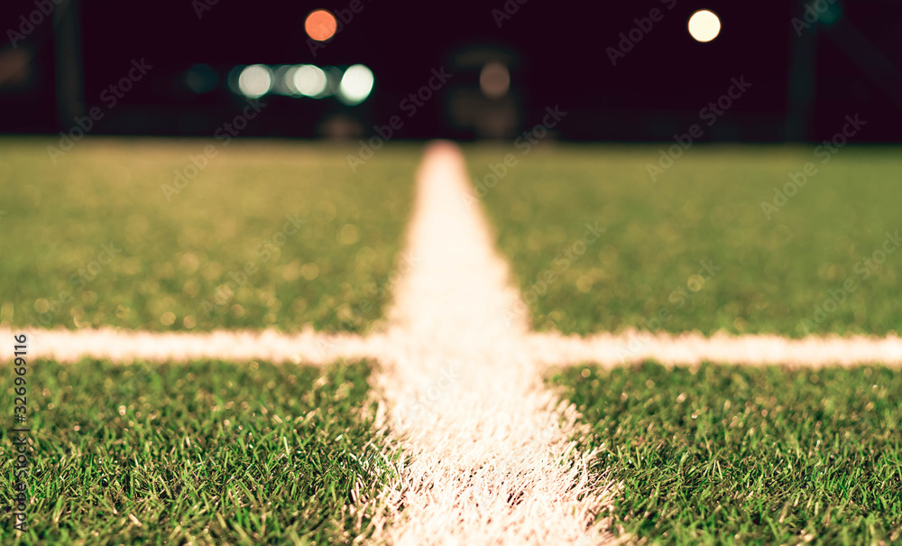 Naklejka premium Widok sztucznej murawy z linii środkowej boiska piłkarskiego