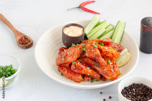 Spicy Baked Chicken Wings Served with Maonaisse Dip, Cucumber, Lemon, Red Chili, Black Pepper and Sesame Seeds,  Low Angle Horizontal Stock Photo