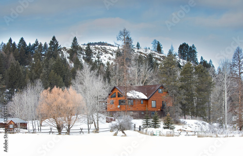 фотографія Country homestead cabin with white frozen trees in winter on a cold morning in M