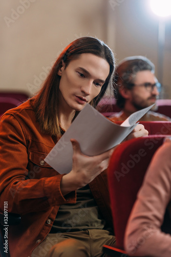 young emotional actors reading screenplay in theatre