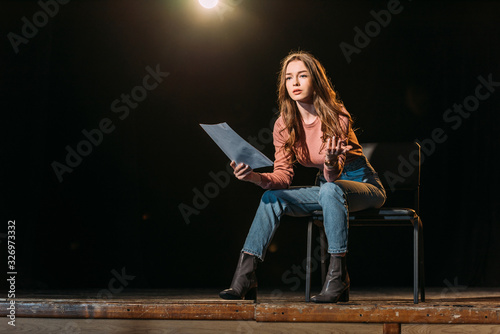 Canvas Print attractive young actress with scenario performing role on stage in theatre