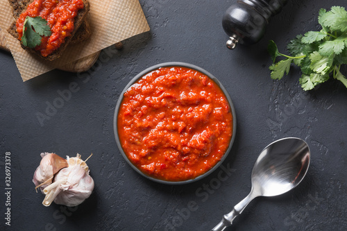 Tasty ajvar. Vegetable sauce or caviar of baked red bell pepper on black. Balkan cuisine. photo