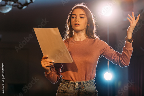 Tela young actress reading scenario on stage in theatre