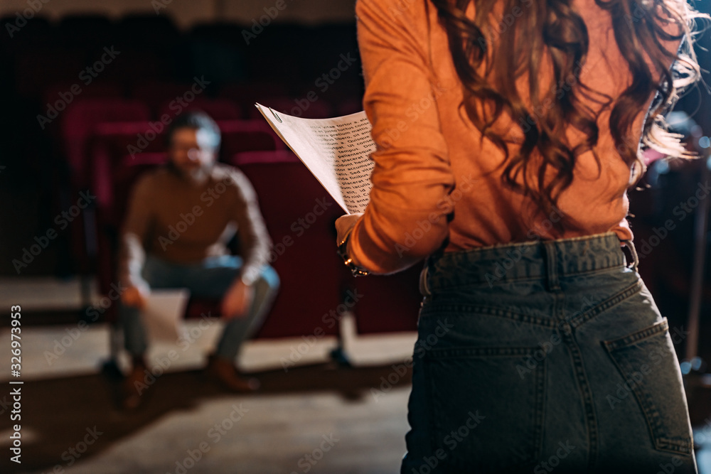 selective focus of theater director and actress with screenplay on stage