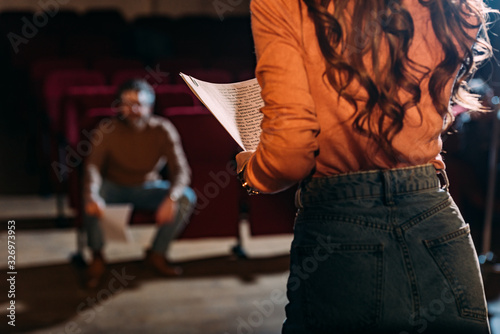 Photo selective focus of theater director and actress with screenplay on stage