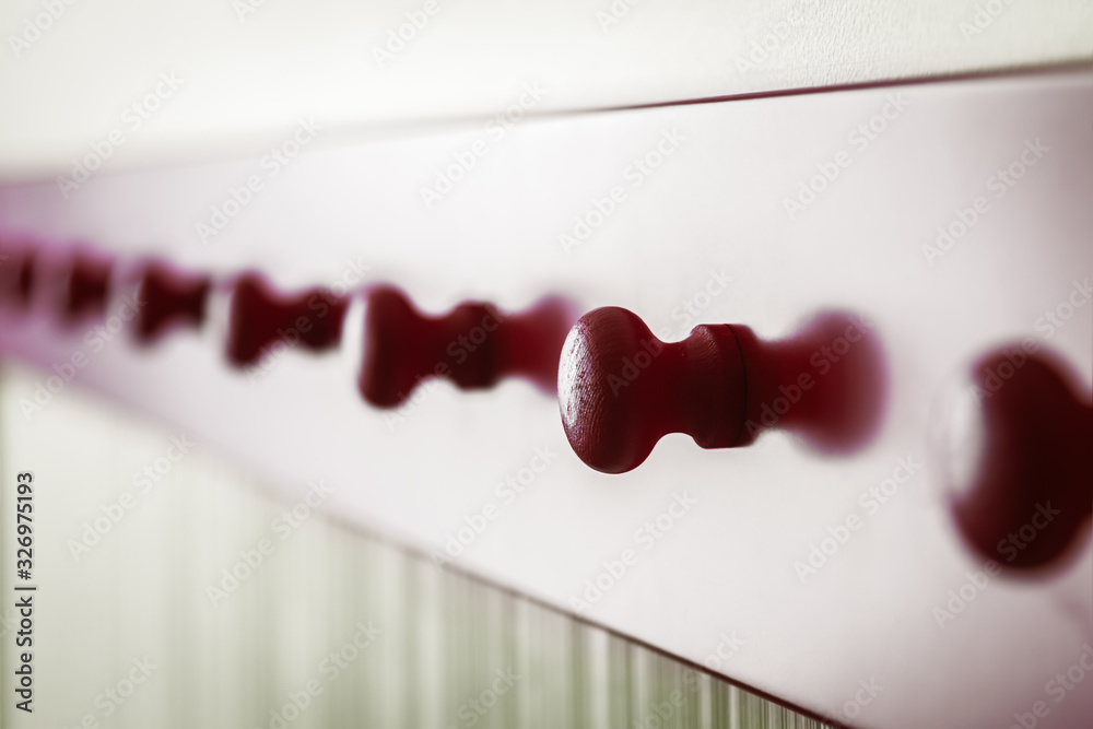 wooden red long hanger along the wall. Shallow depth of field, contour light wooden red long hanger along the wall. Shallow depth of field, contour light