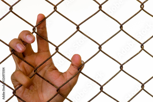 The youth's hand clings to the barbed wire that hinders his freedom.