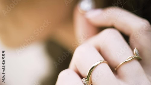 Beautiful woman puts on beautiful earrings. Action. Close up of woman hands touhing her earring with diamonds, jewelry concept. photo