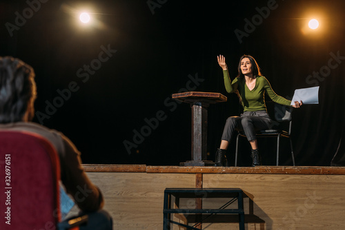 selective focus of theater director and actress performing role on stage