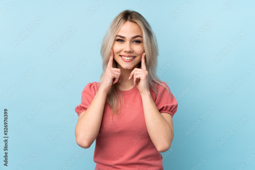 Teenager girl over isolated blue background smiling with a happy and pleasant expression Teenager girl over isolated blue background smiling with a happy and pleasant expression