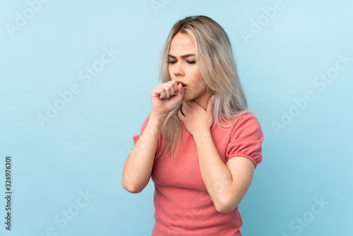 Teenager girl over isolated blue background is suffering with cough and feeling bad