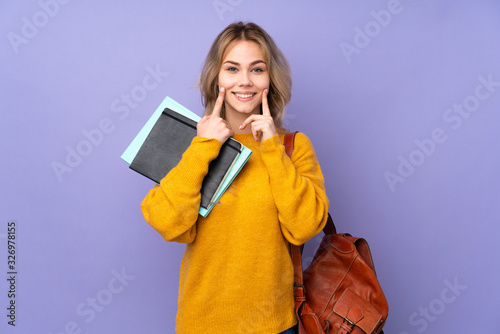 Teenager Russian student girl isolated on purple background smiling with a happy and pleasant expression