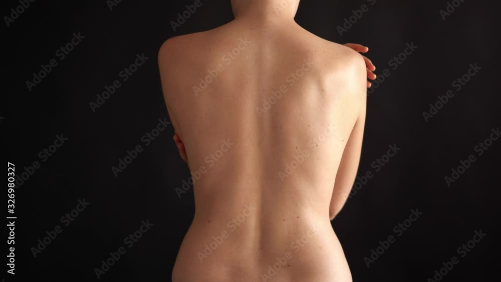 people, health and lifestyle concept - figure of a naked woman in the studio on a black background, rear view from the back. Slim tanned woman's body people, health and lifestyle concept - figure of a naked woman in the studio on a black background, rear view from the back. Slim tanned woman's body