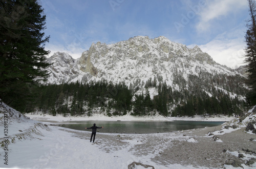 Man looking at Green lake (Gruner see) in sunny winter day. Famous tourist destination for walking and trekking in Styria region, Austria © Aron M  - Austria