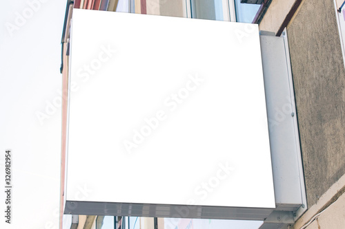 Mockup of the white blank square hanging logo sign in frame on the building wall or facade