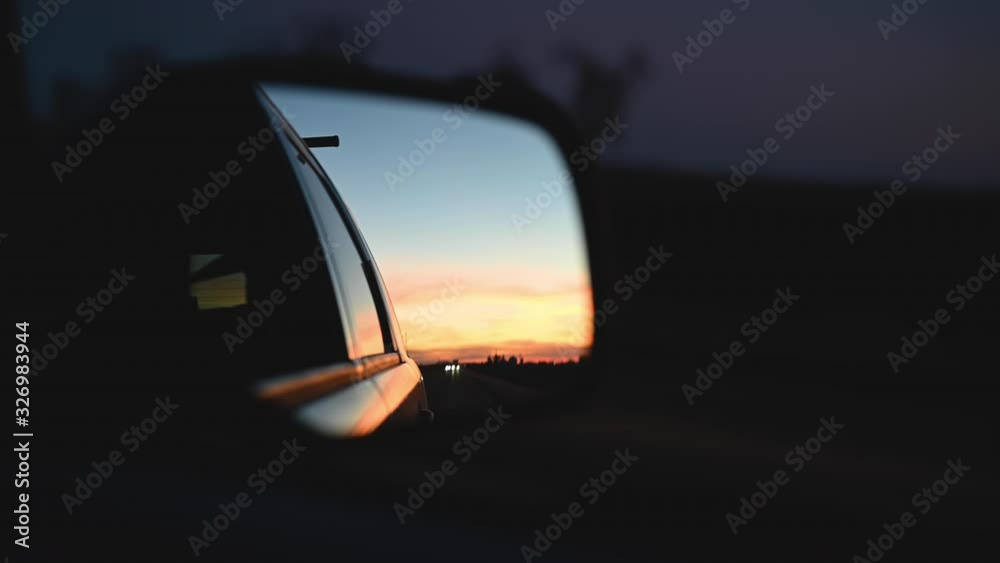 sunset reflected in car side view mirror