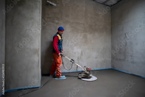 Obraz na płótnie worker performing and polishing sand and cement screed floor