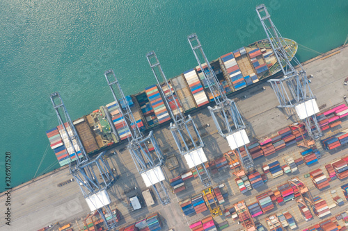 Container ship in export and import business and logistics. Shipping cargo to harbor by crane. Water transport International. Aerial view and top view.