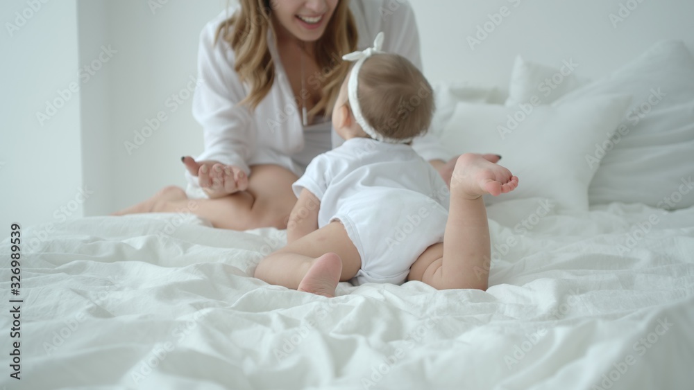 Cute Infant Baby Girl Climbing On The Bed And Crawling To Her Mom Cute Infant Baby Girl Climbing On The Bed And Crawling To Her Mom