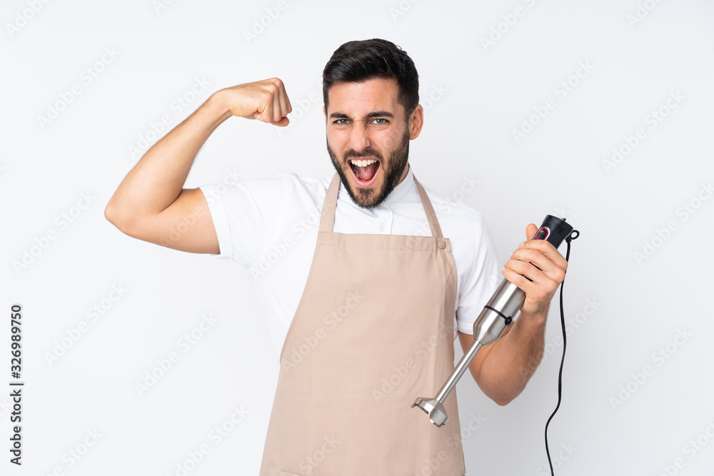 Man using hand blender isolated on white background making strong gesture Man using hand blender isolated on white background making strong gesture