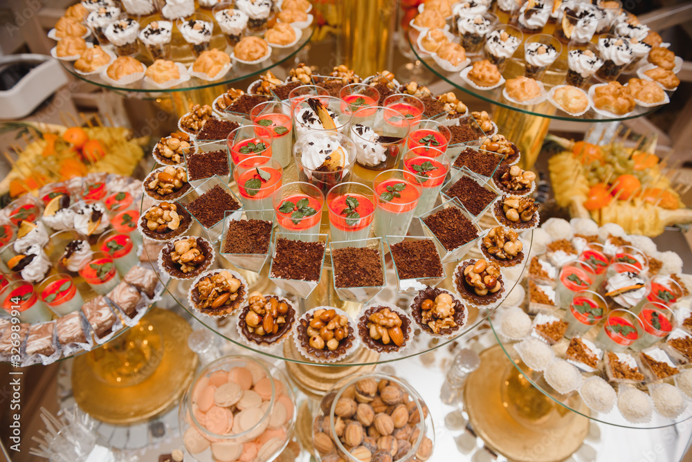 desserts with fruits, mousse, biscuits. Different types of sweet pastries, small colorful sweet cakes, macaron, and other desserts in the sweet buffet. candy bar for birthday