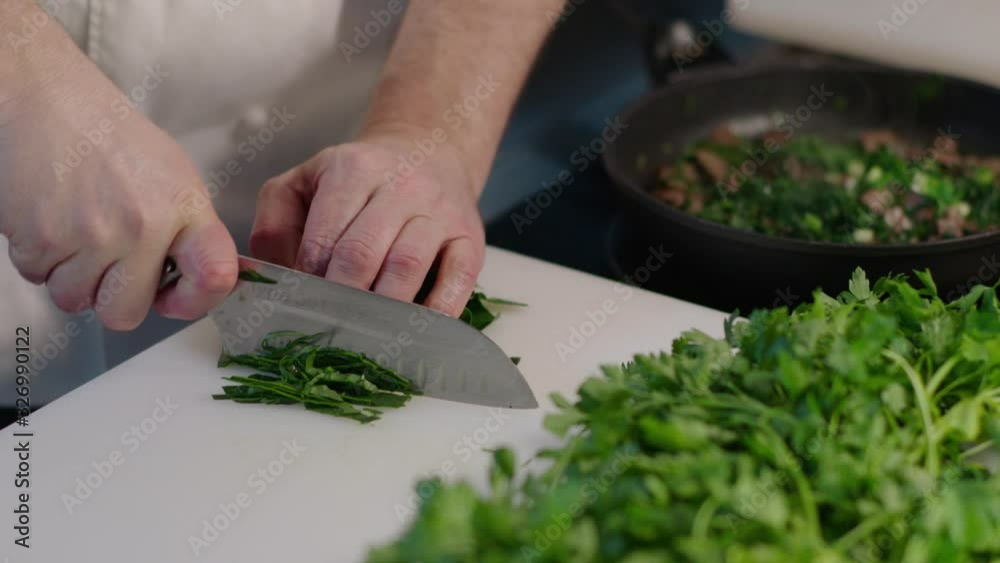 chef cutting parsley in kitchen chef cutting parsley in kitchen
